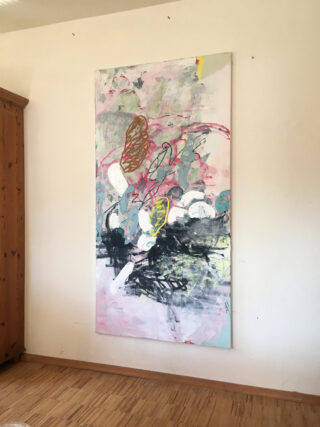 Ein großes abstraktes Gemälde mit geschichteten Farben, Formen und Kritzeleien ist an einer hellen Wand in einem Raum mit Holzboden angebracht.