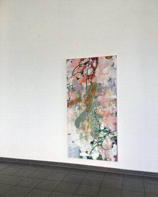 Ein einzelnes abstraktes Gemälde in Pastell- und Erdtönen hängt an einer schlichten weißen Wand über einem grau gefliesten Boden.