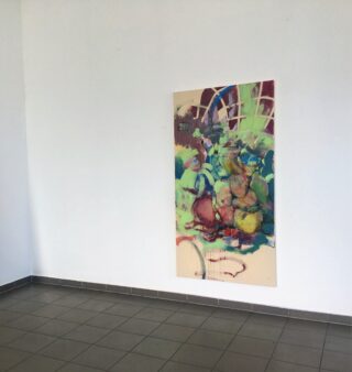 Ein farbenfrohes abstraktes Gemälde hängt an einer weißen Wand in einem weitgehend leeren Raum mit grau gefliestem Boden.