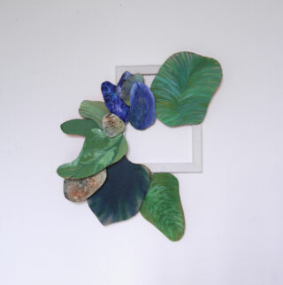 Abstrakte Wandkunst mit grünen und blauen blattförmigen Stücken, die um einen weißen quadratischen Rahmen auf einem schlichten weißen Hintergrund angeordnet sind.