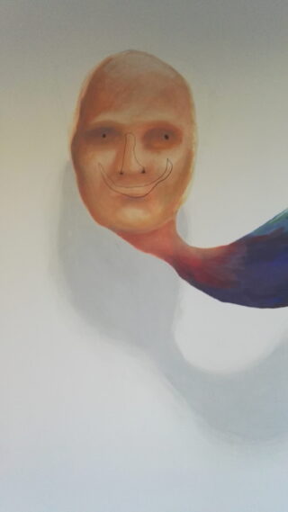 Ein gemaltes abstraktes Gesicht mit einem schwachen Lächeln auf hellem Hintergrund, verbunden mit einer geschwungenen, mehrfarbigen Form, die sich nach rechts erstreckt.