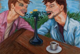 Zwei Männer sitzen an einem Tisch, zwischen ihnen steht eine Vase mit gelben Blumen. Einer scheint in eine Blume zu beißen, und vor ihnen steht eine Tasse Kaffee.