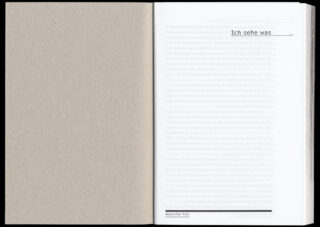 Ein offenes Buch mit einer leeren linken Seite und einer rechten Seite, auf der in Fettdruck „Ich sehe was“ steht, mit schwachem, unleserlichem Text im Hintergrund.