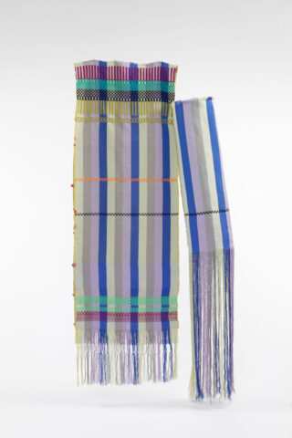 Ein gewebter Stoff mit vertikalen und horizontalen Streifen in verschiedenen Farben und Fransen an der Unterseite und an einer Seite.