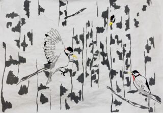 Drei Spechte mit roten Hauben sitzen zwischen senkrechten Baumstämmen, einer davon mitten im Flug, vor einem grauen Waldhintergrund.