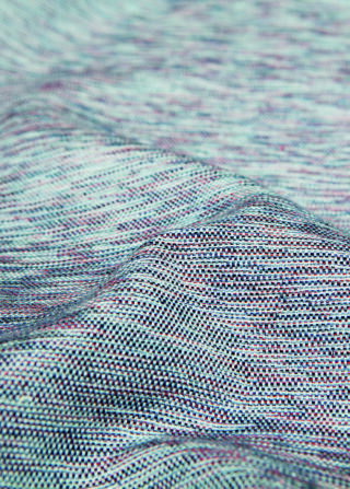 Nahaufnahme eines strukturierten, mehrfarbigen Gewebes mit kleinen Rillen und Variationen im Webmuster.