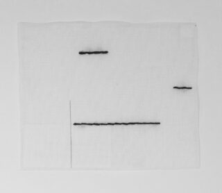 Ein weißes Stoffquadrat mit mehreren kurzen, geraden schwarzen Stichlinien und einer dünnen, hellgrauen vertikalen Linie.