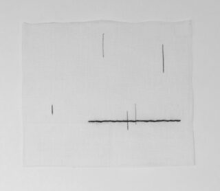 Ein Stück weißer Stoff mit fünf kurzen, geraden schwarzen Nähten, die horizontal und vertikal in einem minimalen Muster angeordnet sind.