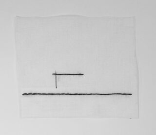 Ein weißes quadratisches Tuch mit einer dünnen schwarzen horizontalen Linie am unteren Rand und einer kurzen vertikalen Linie, die es etwas links von der Mitte schneidet.