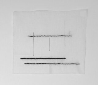 Ein weißes quadratisches Tuch mit drei horizontalen schwarzen Nählinien und drei vertikalen Nählinien unterschiedlicher Länge, die ein abstraktes geometrisches Muster bilden.