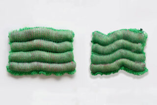 Zwei rechteckige, mit grünem Netz umwickelte Objekte mit wellenförmigen Formen, eines größer auf der linken und eines kleiner auf der rechten Seite, auf einem weißen Hintergrund platziert.