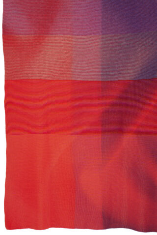 Nahaufnahme eines Stoffes mit horizontalen Streifen in Rot- und Lilatönen, der Struktur und leichte Falten zeigt.