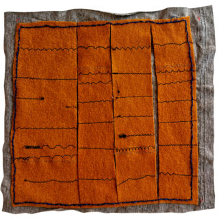 Ein orangefarbener Stoff mit schwarzen Wellen- und Geradenstichen, unterteilt in rechteckige Abschnitte, auf einem grauen Stoffhintergrund.