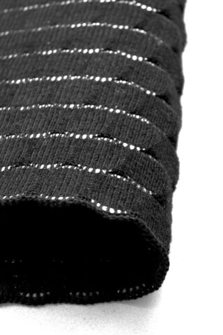 Nahaufnahme eines strukturierten, schwarzen, gerippten Stoffes mit horizontalen Schlitzen, die eine hellere Schicht darunter freigeben, die diagonal auf einer weißen Oberfläche angeordnet ist.