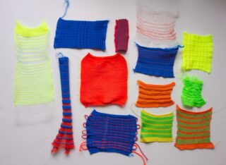 Auf einem weißen Hintergrund sind verschiedene Muster aus Strickstoff in unterschiedlichen leuchtenden Farben und Mustern angeordnet.