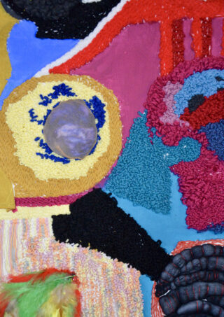 Ein farbenfrohes Textilkunstwerk mit verschiedenen strukturierten Stoffen, Garnen und kreisförmigen Formen in Gelb, Lila, Rot, Blau, Schwarz und Grün.