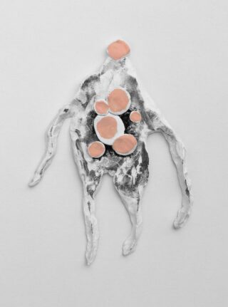 Eine abstrakte, menschenähnliche Figur aus strukturiertem weißem und schwarzem Material mit mehreren pfirsichfarbenen kreisförmigen Formen auf dem Körper, vor einem schlichten weißen Hintergrund.