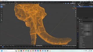 In der Software Blender wird ein 3D-Drahtgittermodell eines Mammutschädels mit Stoßzähnen angezeigt, orange hervorgehoben und mit sichtbaren Bearbeitungssteuerelementen.