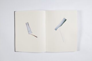 Ein offenes Buch zeigt auf beiden Seiten minimalistische abstrakte Kunst, jede mit einer einfachen geometrischen Form und Linie auf einem schlichten weißen Hintergrund.