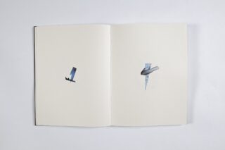 Ein offenes Buch zeigt zwei Seiten, jede mit einem kleinen abstrakten ausgeschnittenen Bild in der Mitte eines ansonsten leeren weißen Hintergrunds.