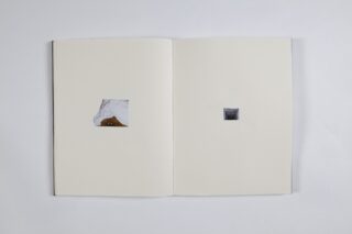 Ein offenes Buch mit zwei leeren Seiten; auf der linken Seite ist ein kleines Foto von Stoff und braunem Material, auf der rechten Seite ein kleineres Foto einer dunklen strukturierten Oberfläche.