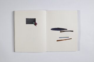 Ein offenes Buch mit abstrakten, ausgeschnittenen Formen und Fragmenten, die auf beiden leeren Seiten vor einem weißen Hintergrund angeordnet sind.