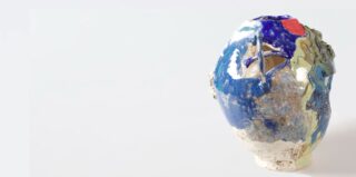 Eine runde Keramikvase mit blauer, weißer, grüner und roter Glasur mit ungleichmäßiger Textur und einer unregelmäßig geformten Öffnung.