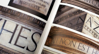 Nahaufnahme eines offenen Buches, das mehrere Bilder antiker Steinmetzarbeiten mit lateinischen Inschriften in großen, eingravierten Großbuchstaben zeigt.