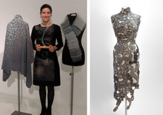 Eine Frau steht neben zwei Schaufensterpuppen, die strukturierte Kleidungsstücke präsentieren; eine andere Schaufensterpuppe auf der rechten Seite präsentiert ein figurbetontes Spitzenkleid mit komplizierten Mustern.