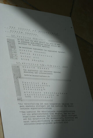 Ein gedruckter Veranstaltungsflyer mit dem Titel „Die Grenzen der Solidarität“ mit Details in Deutsch und Englisch, ausgestellt im schräg einfallenden Sonnenlicht, das Schatten wirft.