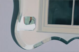 Eine Nahaufnahme eines dekorativen Spiegels, der einen Teil eines Fensters und ein hängendes Objekt an einer hellen Wand reflektiert.