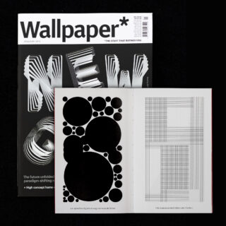 Hinter einem offenen Buch, das auf jeder Seite abstrakte schwarze Kreise und Gitterlinien zeigt, befindet sich ein Wallpaper-Magazin mit einem monochromen geometrischen Cover.