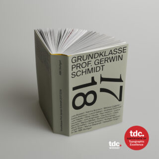 Ein Buch mit dem Titel „Grundklasse Prof. Gerwin Schmidt 17 18“ steht aufrecht mit aufgefächerten Seiten. Auf dem Cover sind Namen aufgeführt und zwei Logos des tdc Typographic Excellence Award abgebildet.