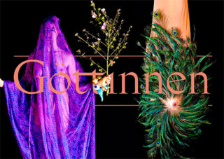 Zwei Figuren sind teilweise bedeckt; eine trägt einen violetten Schleier und hält Blumen, die andere ist mit Pfauenfedern behangen. Das Wort „Göttinnen“ ist in großer rosa Schrift darübergelegt.