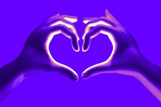 Zwei Hände bilden vor einem leuchtend violetten Hintergrund die Form eines Herzens, wobei gelbe Akzente die Finger betonen.