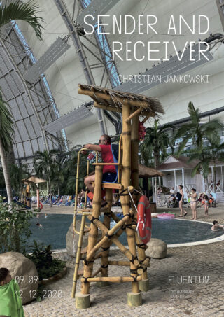 Ein Rettungsschwimmer sitzt auf einem Holzturm neben einem Innenpool, umgeben von tropischen Pflanzen. Darüber liegt der Ausstellungstext „Sender und Empfänger“ von Christian Jankowski.