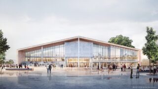 Ein modernes Gebäude mit großen Glasfenstern und einem schrägen Dach, umgeben von Menschen, die auf einem offenen Platz mit Bäumen spazieren gehen.