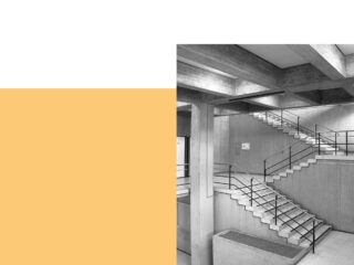 Schwarzweißfoto einer modernen Betontreppe mit Metallgeländer vor einem Hintergrund aus weißen und senfgelben Blöcken.