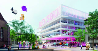 Ein modernes, mehrstöckiges Glasgebäude mit rosa Lichtern und großen Ballons mit Comicfiguren auf dem umliegenden Platz. Draußen laufen und versammeln sich Menschen.