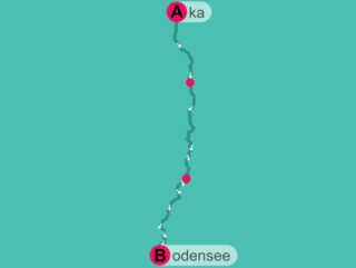 Eine einfache Karte, die eine Route von Punkt A (mit der Bezeichnung Aka) oben zu Punkt B (mit der Bezeichnung Bodensee) unten zeigt, mit zwei markierten Haltestellen entlang des Weges.