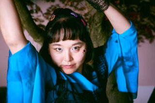 Portrait einer jungen Frau im blauen Kleid.