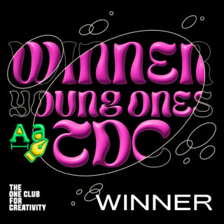 Der fettgedruckte rosa Text lautet „WINNER YOUNG ONES TDC“ mit einer Grafik aus Buchstaben und einer Stiftspitze. „THE ONE CLUB FOR CREATIVITY“ und „WINNER“ erscheinen in weißer Schrift auf schwarzem Hintergrund.