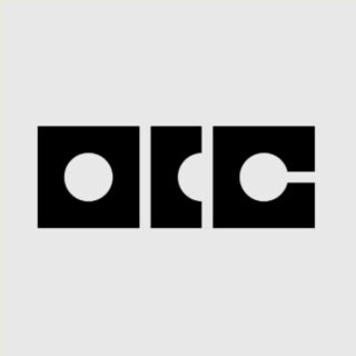 Drei schwarze geometrische Formen mit kreisförmigen Ausschnitten sind in einer Reihe auf einem hellgrauen Hintergrund angeordnet.