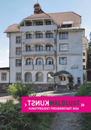 Ein großes, altes Hotelgebäude mit einem Schild mit der Aufschrift „Kulturdenkmal Hotel Waldlust“ und einem Banner darunter mit der Aufschrift „Kunst Waldlust Kunstprojekt Freudenstadt 2024“.