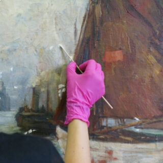Eine Person mit einem rosa Handschuh reinigt oder restauriert mit einem Wattestäbchen eine bemalte Leinwand mit einem Boot.