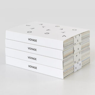 Vier gestapelte weiße Bücher mit dem Titel „VOYAGE“ und minimalistischem schwarzen Text auf den Buchrücken vor einem schlichten hellen Hintergrund.