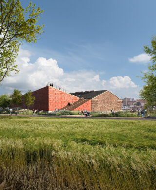 Ein modernes Gebäude aus rotem Backstein mit einer schrägen Dachterrasse steht neben einem älteren Backsteingebäude, umgeben von grünem Gras und Bäumen unter einem teilweise bewölkten Himmel. Menschen gehen in der Nähe spazieren.