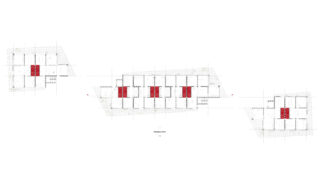 Architektonische Grundrisszeichnung von drei durch Korridore verbundenen Gebäudeteilen mit rot hervorgehobenen Bereichen, die bestimmte Räume oder Zonen kennzeichnen.