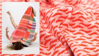 Eine Person liegt auf dem Rücken, die Beine und Arme sind angehoben, teilweise bedeckt von einem bunt gemusterten Textil; im Hintergrund ist eine Nahaufnahme eines rot-weißen Webstoffs zu sehen.