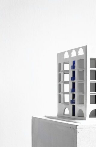 Ein minimalistisches Architekturmodell eines modernen Gebäudes mit Bogenfenstern und Balkonen, präsentiert auf einem weißen Sockel vor einem schlichten Hintergrund.